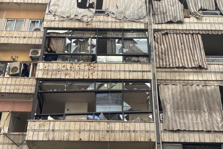 A woman checks the scene of a missile strike from her damaged house in the southern suburbs of Beirut, Friday, Sept. 20, 2024. (AP Photo/Bilal Hussein)