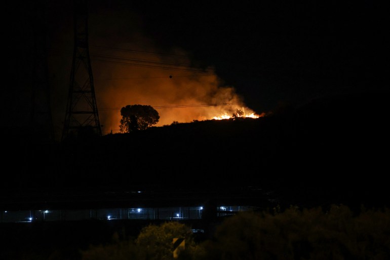 Fire erupts between Ben Gurion International Airport near Tel Aviv and the city of Modiin following an Iranian missile attack, on October 1, 2024. - Iran's Revolutionary Guards said a missile attack under way against Israel on October 1 was in response to the killing of Hezbollah chief Hassan Nasrallah last week as well as that of the Hamas leader. (Photo by Ahmad GHARABLI / AFP)