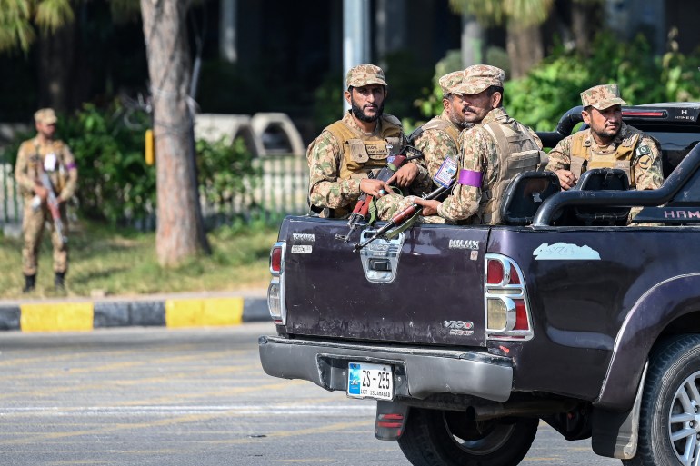 Army personnel sitting on a vehicle patrol at the Red Zone near a venue on the eve of the Shanghai Cooperation Organisation (SCO) summit in Islamabad on October 14, 2024. - Pakistan authorities were preparing on October 13 to shut down the capital ahead of a Shanghai Cooperation Organisation summit, overshadowed by recent militant violence and political unrest. (Photo by Aamir QURESHI / AFP)