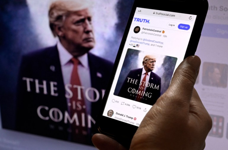 In this photo illustration, Donald Trump's TRUTH Social account is seen on a mobile device with an image of former US president Donald Trump in the background in Washington, DC on September 13, 2022. (Photo by OLIVIER DOULIERY / AFP)