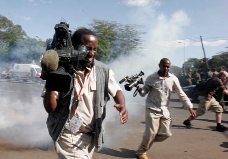 Journalists run for cover as riot police fire teargas and grenades to disperse opposition supporters in Nairobi, January 4, 2008. President Mwai Kibaki is open to the idea of a coalition government to end Kenya's post-election crisis but only if the opposition meets his terms, South African Nobel laureate Desmond Tutu said on Friday. REUTERS/Thomas Mukoya (KENYA)