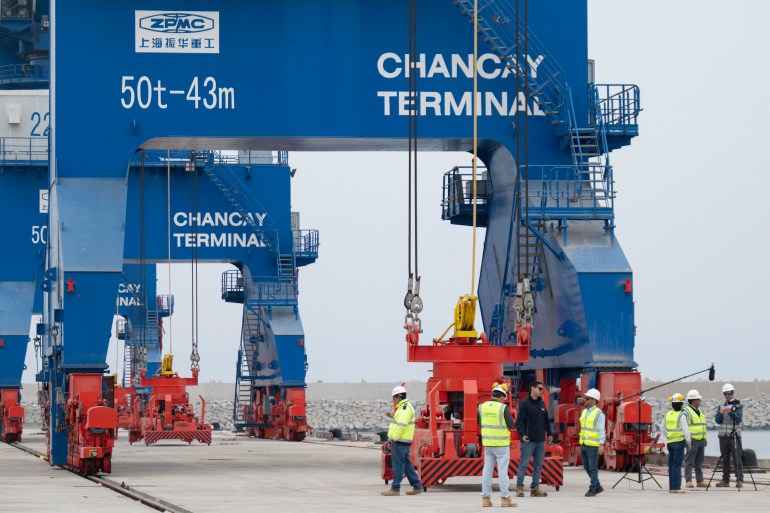 Workers are seen at the Chancay "megaport" in the small town of Chancay, 78 kilometers north of the Peruvian capital Lima, on October 29, 2024. - The port will be inaugurated on November 14, 2024, by Peruvian President Dina Boluarte and her Chinese counterpart, Xi Jinping, on the sidelines of the Asia-Pacific Economic Cooperation (APEC) summit in Lima. (Photo by Cris BOURONCLE / AFP)