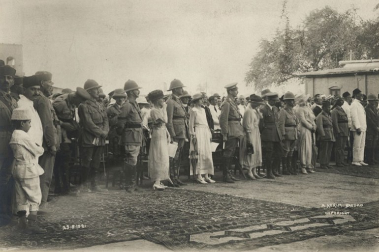 1921-08-23 Gertrude Bell. Dignitaries - including Gertrude Bell, (left of centre holding eye glasses) Lady Cox, the Garbetts and Mrs Slater, and Officers at the Coronation of King Faisal in Sarai Courtyard - Government buildings. (نيوكاسيل)