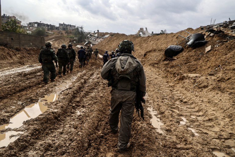 --PHOTO TAKEN DURING A CONTROLLED TOUR AND SUBSEQUENTLY EDITED UNDER THE SUPERVISION OF THE ISRAELI MILITARY-- This picture taken during a media tour organised by the Israeli military on January 27, 2024, shows Israeli soldiers patrolling an area in Gaza's main southern city of Khan Yunis, amid continuing battles between Israel and the Palestinian militant group Hamas. (Photo by Nicolas GARCIA / AFP)