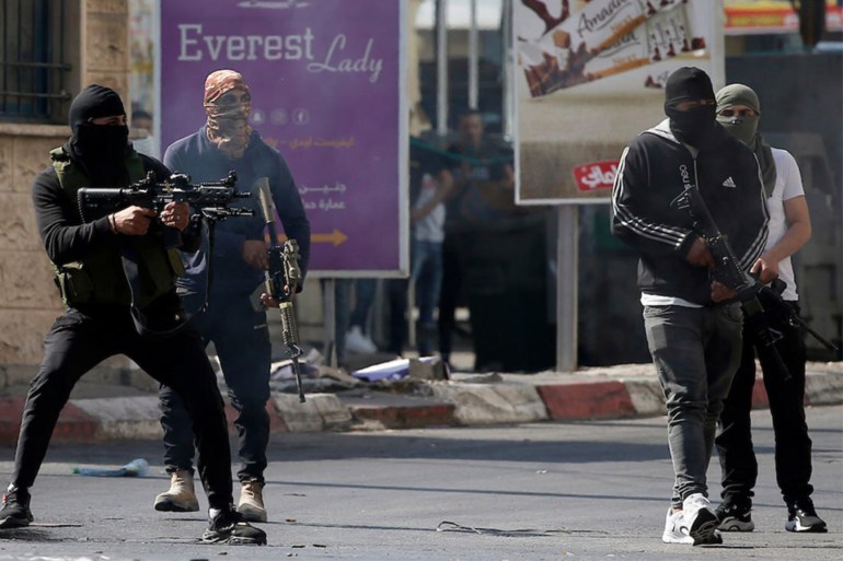 Palestinian armed militants take up position during a confrontation with Israeli army in the occupied West Bank city of Jenin on July 3, 2023. The Israeli army said it had launched drone strikes in Jenin as part of an "extensive counterterrorism effort" that the Palestinian health ministry said killed four residents. (Photo by Jaafar ASHTIYEH / AFP)