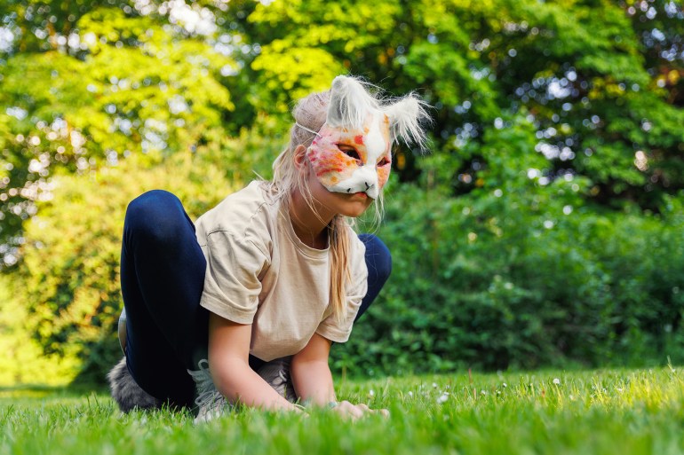Cute young little kid girl wear cat furry mask enjoy have fun playing outdoors in forest street park. Children therian wild animal character trendy fan culture. Teenager social expression hobby; Shutterstock ID 2461875573; purchase_order: aj; job: ; client: ; other: