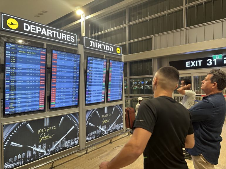 TEL AVIV, ISRAEL - OCTOBER 8: People look at the board showing departure schedules at Ben Gurion Airport, Israel's only international airport, after many flights from abroad are cancelled due to the attacks launched by Palestinian factions in Tel Aviv, Israel on October 8, 2023. ( Turgut Alp Boyraz - Anadolu Agency )