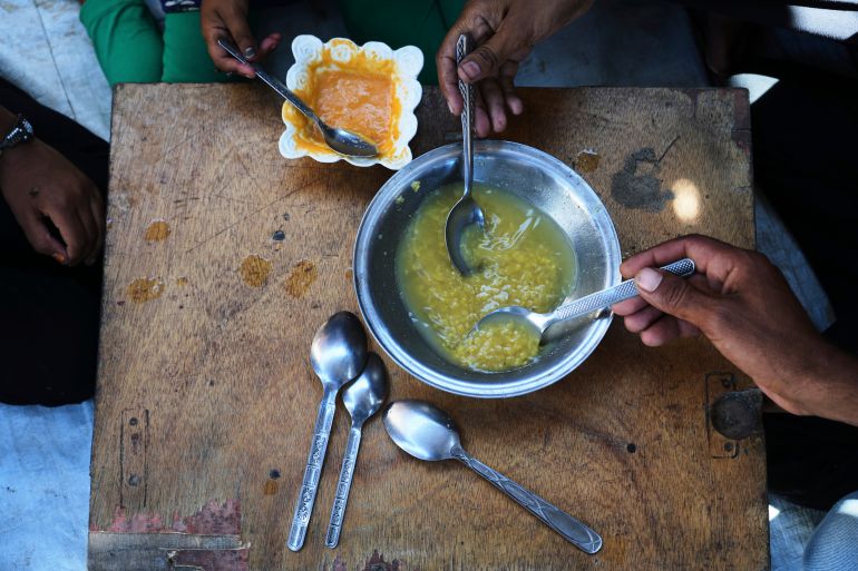 The Al-Arja family eats lentil soup inside their tent in a camp for displaced Palestinians in Muwasi, Khan Younis, Gaza, Wednesday, May 21, 2025. (AP Photo/Abdel Kareem Hana)