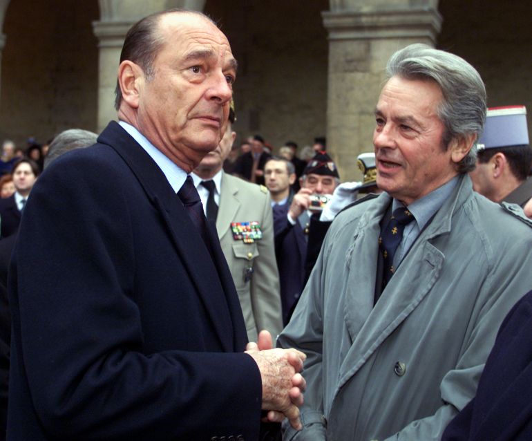 French President Jacques Chirac (L) speaks with French actor Alain Delon at les Invalides in Paris, January 11, 2002. Chirac and Delon were attending a ceremony to commemorate the fiftieth anniversary of the death of former military hero [Marechal Delatre de Tassigny.]