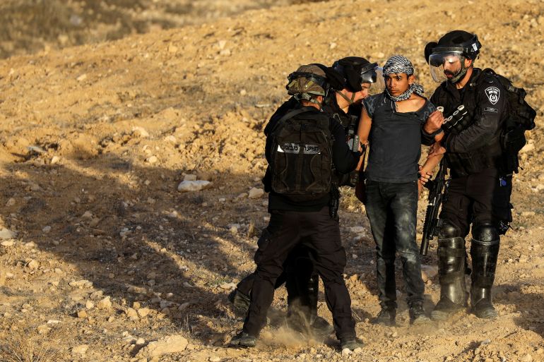 Israeli police force detain a Bedouin man during a protest against forestation at the Negev desert village of Sawe al-Atrash, southern Israel, January 13, 2022. REUTERS/Ammar Awad