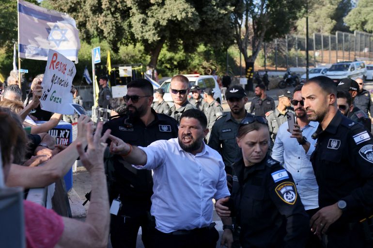 Israeli member of parliament Almog Cohen (C) argues with ativists demonstrating outside the Israeli Parliament in support of Ayman Odeh, of Israel's Arab Front for Change (Hadash), ahead of a vote to oust the Arab-Israeli lawmaker from the Knesset, on July 14, 2025. (Photo by AHMAD GHARABLI / AFP)
