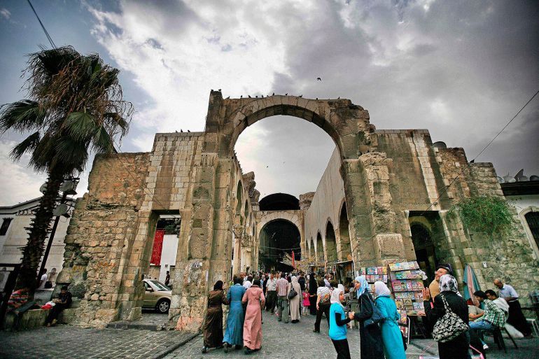 Damascus,Syria - August 04,2010 : Damascus, Syria,people around the mall.Pre-war Damascus,Syria.People sit around in a central square in Damascus. Ruins of ancient roman structures can be seen.