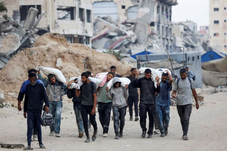 Palestinians carry aid supplies after trucks loaded with aid entered from Israel through central Gaza, in Gaza City July 22, 2025. REUTERS/Khamis Al-Rifi TPX IMAGES OF THE DAY