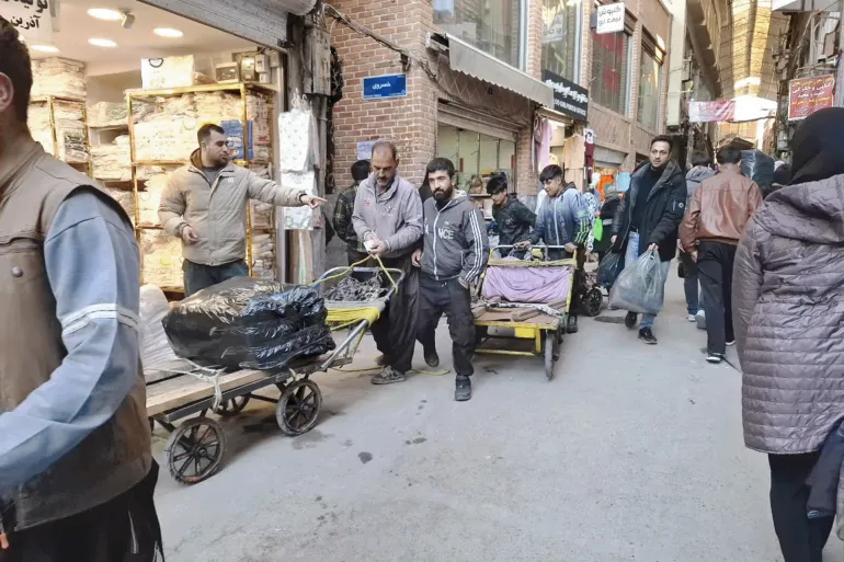 أحد سائقي العربات اليدوية في سوق عباس آباد يقول أن عمله انخض للنصف مؤخرا (الجزيرة)