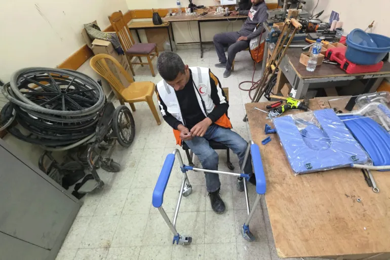 بإمكانيات متواضعة يعمل رمزي الفجم داخل ورشة صغيرة بجمعية الهلال الأحمر الفلسطيني لتصليح كراسي متحركة وأدوات مساعدة لذوي الإعاقة وجرحى الحرب-رائد موسى-خان يونس-الجزيرة نت