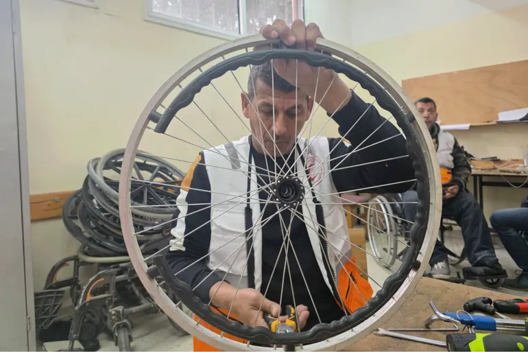 يقضي رمزي الفجم يومه في تصليح كراسي متحركة مستعملة وأدوات مساعدة لذوي الإعاقة وجرحى الحرب على غزة-رائد موسى-خان يونس-الجزيرة نت