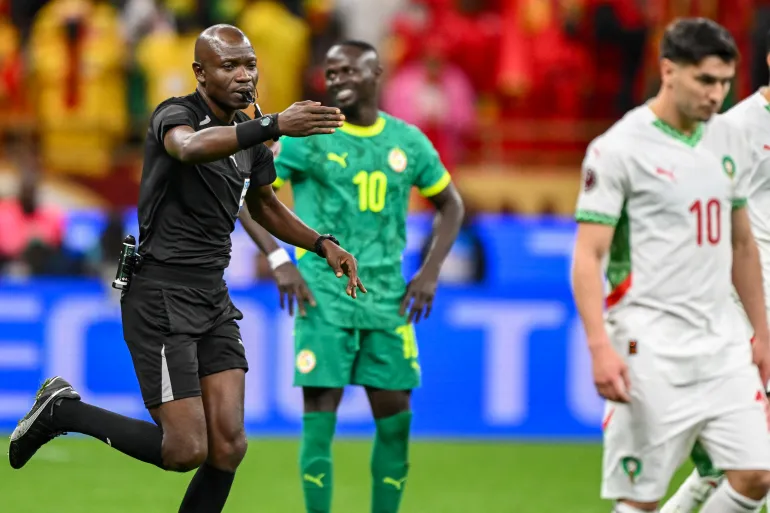 Congolese referee Jean-Jacques Ndala Ngambo whistles a penalty as Senegal's forward #10 Sadio Mane and Morocco's forward #10 Brahim Diaz react during the Africa Cup of Nations (CAN) final football match between Senegal and Morocco at the Prince Moulay Abdellah Stadium in Rabat on January 18, 2026.