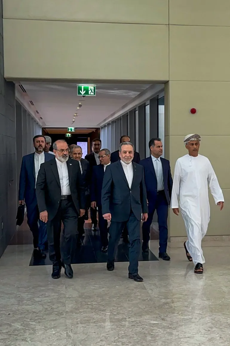 In this handout photo obtained from Iran’s foreign ministry delegation on February 6, 2026, Iran’s Foreign Minister Abbas Araghchi (C) arrives for a meeting in Muscat.