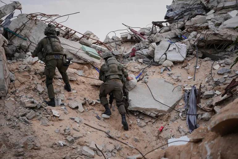 Israeli soldiers climb on the rubble next to the entrance of a tunnel in Rafah, Gaza Strip, Monday, Dec. 8, 2025. (AP Photo/Sam Mednick)