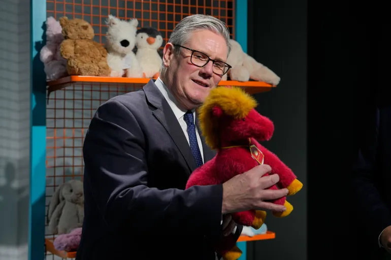 Britain's Prime Minister Keir Starmer holds up a horse doll at the House of UK in Shanghai, China, Friday, Jan. 30, 2026. (AP Photo/Kin Cheung, Pool)