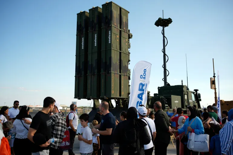 People walk past an air defense system produced by Turkish weapons manufacturer Aselsan displayed during Teknofest fair, at Ataturk airport, in Istanbul, Turkey, Saturday, Sept. 20, 2025. (AP Photo/Emrah Gurel)