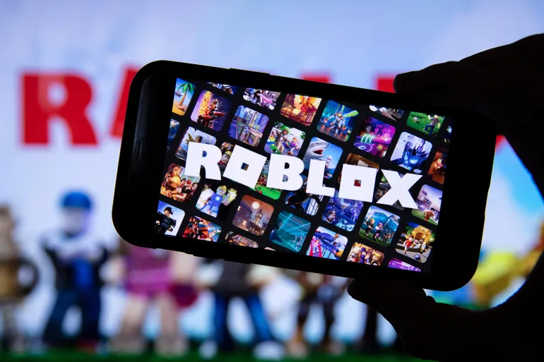 LONDON, UK - March 2021: Person holding a smartphone with Roblox game logo