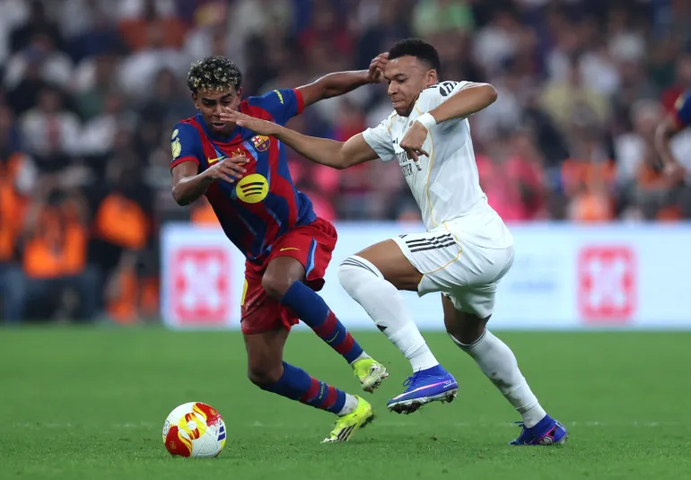 JEDDAH, SAUDI ARABIA - JANUARY 11: Kylian Mbappe of Real Madrid battles for possession with Lamine Yamal of FC Barcelona during the Spanish Super Cup Final between FC Barcelona and Real Madrid at King Abdullah Sports City Hall Stadium on January 11, 2026 in Jeddah, Saudi Arabia. (Photo by Yasser Bakhsh/Getty Images)