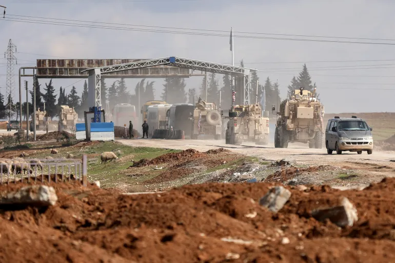 FILE PHOTO: U.S. military vehicles escort buses transporting Islamic State detainees from Syria to Iraq, according to a security source from the Syrian Democratic Forces, in Qamishli, Syria, February 8, 2026. REUTERS/Orhan Qereman/File Photo