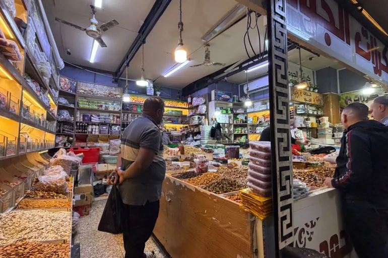 بغداديون يقفون أمام أحد محال العطارة داخل سوق الشورجة