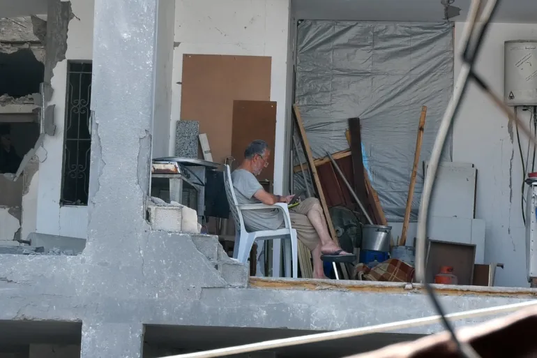 سطين -غزة. مسن من عائلة مقداد يجلس صامدًا وسط ركام منزله الذي دمره القصف الإسرائيلي. ١٦ مارس 2026 – تصوير الجزيرة نت.