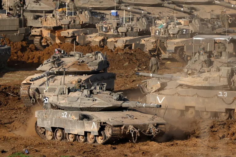 Israeli army tanks deploy at a position in the Upper Galilee in northern Israel near the border with Lebanon on March 12, 2026.