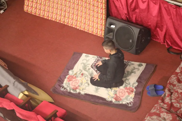 شاب نازح يؤدي الصلاة تحت خشبة المسرح