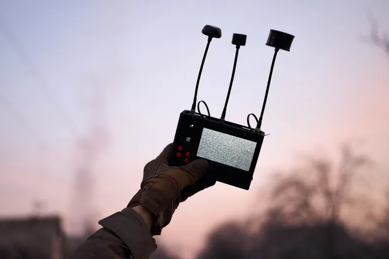 KOSTIANTYNIVKA DISTRICT, UKRAINE - FEBRUARY 11: A Ukrainian serviceman monitors the sky using a handheld drone detection device designed to identify the presence and signal activity of nearby FPV attack drones, scanning for potential aerial threats while stationed near the road between Kostiantynivka and Druzhkivka in the Donetsk region amid ongoing combat operations on February 11, 2026 in Kostiantynivka District, Ukraine. (Photo by Kostiantyn Liberov/Libkos/Getty Images)