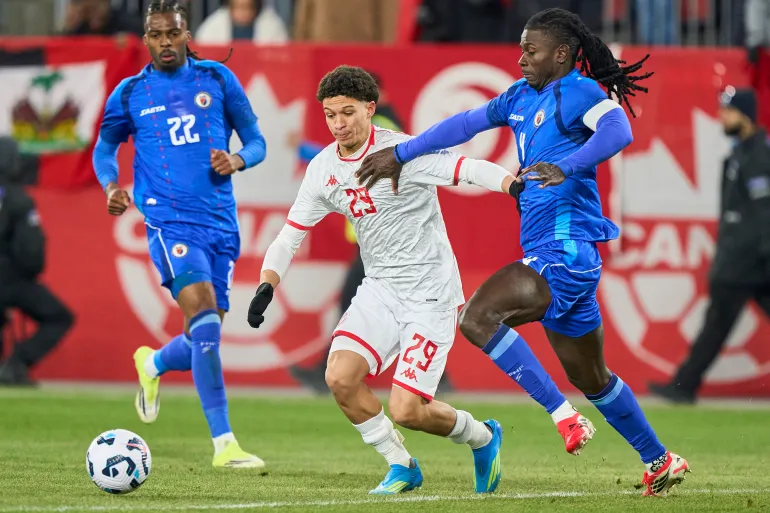 Tunisia's forward #29 Louey Ben Farhat vies for the ball with Haiti's defender #22 Jean-Kevin Duverne and Haiti's defender #04 Ricardo Ade during a friendly football match between Haiti and Tunisia at BMO Field in Toronto, Canada, on March 28, 2026.