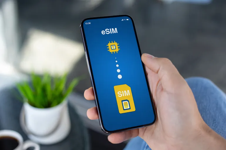 Man hand hold phone with Sim card replacement on eSim on screen in cafe