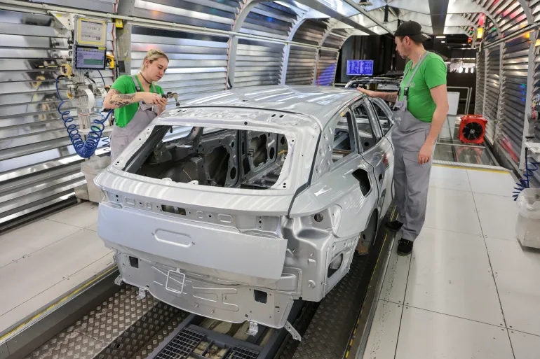 EMDEN, GERMANY - FEBRUARY 24: Volkswagen assembly worker perform final checks and corrections on ID line electric cars in the paint shop at the Volkswagen electric car factory on February 24, 2026 in Emden, Germany. Volkswagen rose in 2025 to first place in electric car sales in Europe, beating out rival Tesla. (Photo by Focke Strangmann/Getty Images)