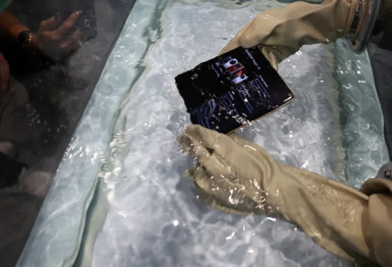 A Honor Magic V6 foldable phone is submerged in water by a member of staff as the company unveils their new products ahead of Mobile World Congress Barcelona, Spain Spain March 1, 2026. REUTERS/Nacho Doce