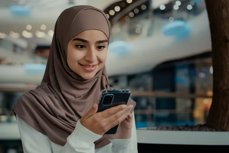 Young arabian latina woman student girl look at mobile screen shopping online buying goods in virtual store use phone digital apps read blog news female businesswoman shopper check internet discounts