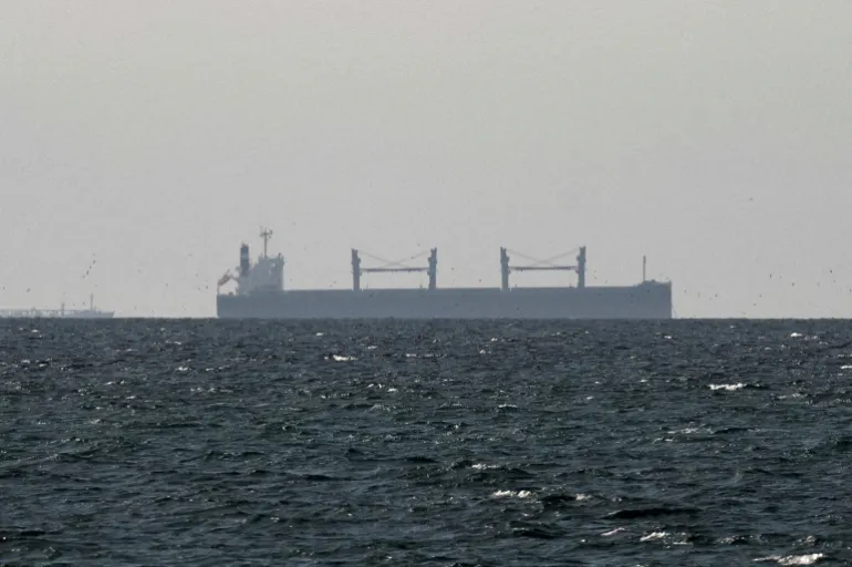 FILE PHOTO: A cargo ship in the Gulf, near the Strait of Hormuz, as seen from northern Ras al-Khaimah, near the border with Oman’s Musandam governance, amid the U.S.-Israeli conflict with Iran, in United Arab Emirates, March 11, 2026. REUTERS/Stringer/File Photo/File Photo/File Photo