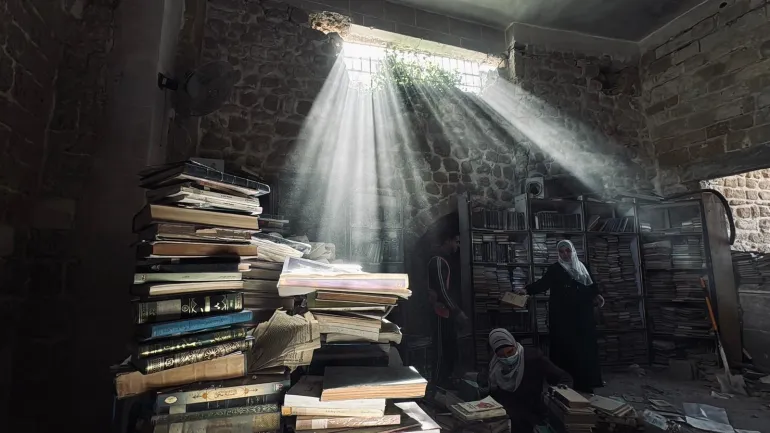 فلسطين - غزة-فريق تطوعي بإسعاف مخطوطات أثرية نادرة تم انتشالها من تحت أنقاض دائرة مخطوطات المسجد العمري - للحفاظ على ما تبقّى منها.- يسرى العكلوك -الجزيرة نت 11 أبريل 2026