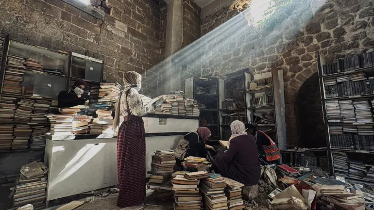 فلسطين - غزة-فريق تطوعي بإسعاف مخطوطات أثرية نادرة تم انتشالها من تحت أنقاض دائرة مخطوطات المسجد العمري - للحفاظ على ما تبقّى منها.- يسرى العكلوك -الجزيرة نت 11 أبريل 2026