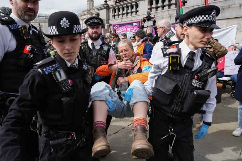 Police carry away a protester as people gather to call for the lifting of the ban on the Palestine Action group during a demonstration in Trafalgar Square in central London on April 11, 2026.