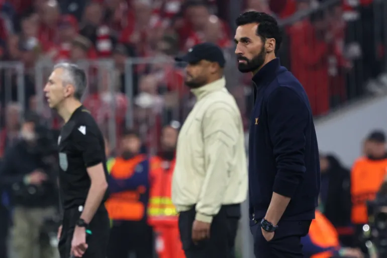 Real Madrid's Spanish head coach Alvaro Arbeloa (R) and Bayern Munich's Belgian head coach Vincent Kompany (C) are seen on the sidelines during the UEFA Champions League quarter-final second leg football match between FC Bayern Munich and Real Madrid in Munich, southern Germany, on April 15, 2026.