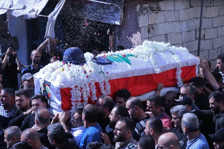 TOPSHOT - Mourners carry the coffin of Lebanese journalist Amal Khalil during her funeral procession in Bissariye town, south of Sidon on April 23, 2026.