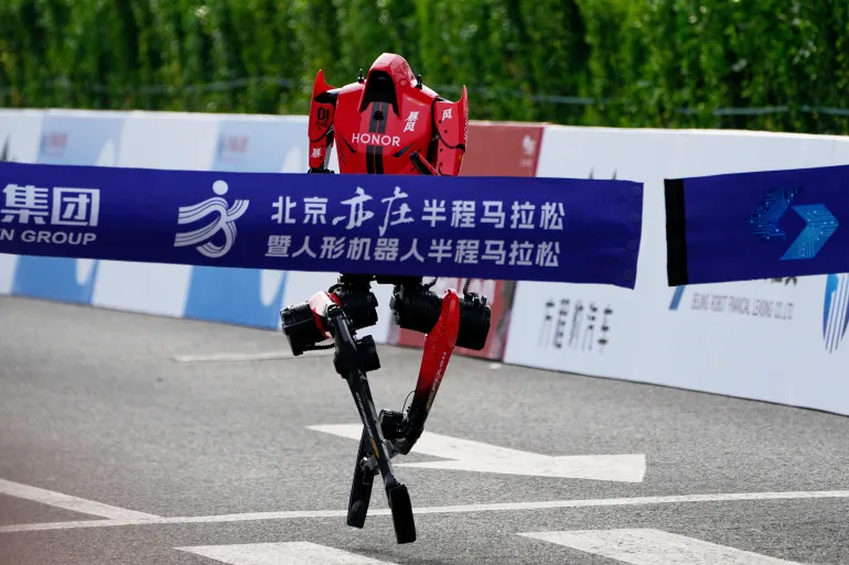 A robot crosses the finish line in the Beijing E-Town Half Marathon and Humanoid Robot Half-Marathon held in the outskirts of Beijing, Sunday, April 19, 2026. (AP Photo/Andy Wong)