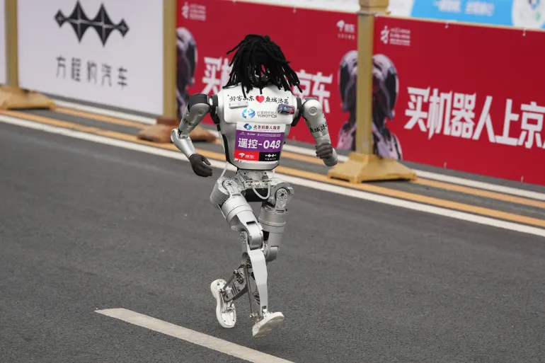 A robot starts off for the Beijing E-Town Half Marathon and Humanoid Half Marathon on the outskirts of Beijing on Sunday, April 19, 2026. (AP Photo/Ng Han Guan)