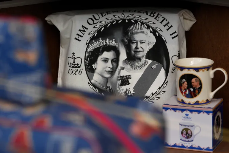 Souvenirs with photos of late Queen Elizabeth II are on display for sale at a souvenirs shop in London, on April 17, 2026. (AP Photo/Kin Cheung)