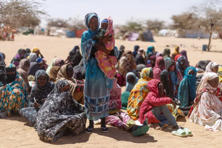 OURE CASSONI, CHAD - FEBRUARY 24: Sudanese refugees wait to be given plastic sheets and other food aid at the Oure Cassoni refugee camp after arriving from Sudan, on February 24, 2026 in Oure Cassoni, Chad. In April 2023 civil war erupted between the Sudanese Armed Forces (SAF) and the armed militia group Rapid Support Forces (RSF). The ongoing conflict has so far displaced around 14 million people across the region, triggering a widespread humanitarian crisis, as neighboring countries like Chad struggle to absorb refugees, while coping with populations already suffering high poverty rates and food insecurity. Chad has become Africa's largest host of refugees per capita, hosting a total 1.4 million refugees - more than 900,000 of which fled the conflict in Sudan. The most recent wave of arrivals from Sudan follows the RSF's offensive to capture the north Darfur city of El Fasher, where 6,000 people were reportedly killed by the RSF in the space of three days in October. A recent UN report has accused the RSF of atrocities that amount to war crimes and possible crimes against humanity. As many as 400,000 people have reportedly been killed since the conflict began. (Photo by Dan Kitwood/Getty Images)