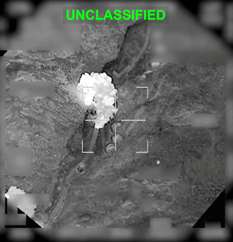 An explosion following a strike on an Iranian facility in Haji Abad, Iran in this still image obtained from a video released by U.S. Central Command (CENTCOM) on March 20, 2026. CENTCOM/Handout via REUTERS THIS IMAGE HAS BEEN SUPPLIED BY A THIRD PARTY. MANDATORY CREDIT. TEXT OVERLAY AND BLURRING FROM SOURCE. VERIFICATION: The location was confirmed from the road layout and infrastructure which matched satellite imagery of the area. The shape of the valley matched the topography mapping of the area. The exact date could not be verified but no older version of the video was found posted online before March 20. The site was identified as an Iranian missile base by several military analysts.
