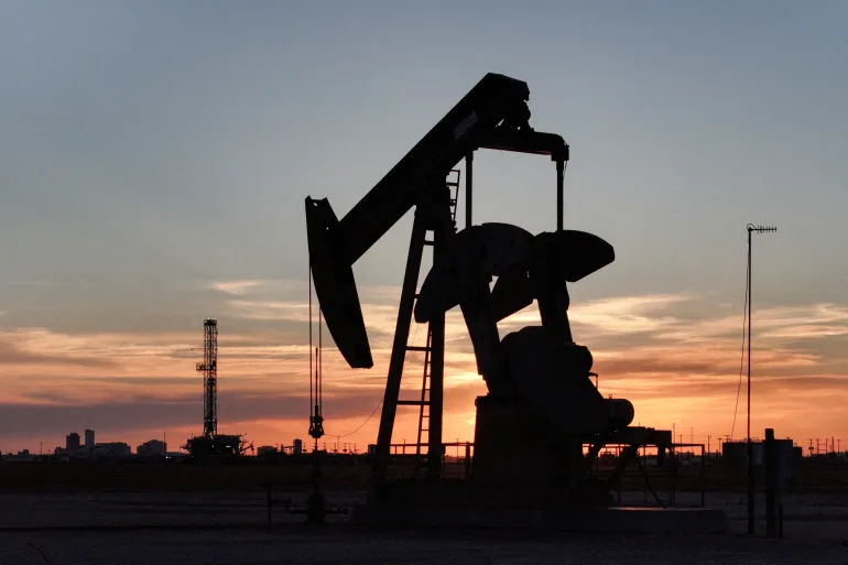 FILE PHOTO: A drone view of a pump jack and drilling rig south of Midland, Texas, U.S. June 11, 2025. REUTERS/Eli Hartman/File Photo
